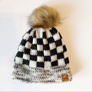 Black and white checkered beanie with a fluff ball on top